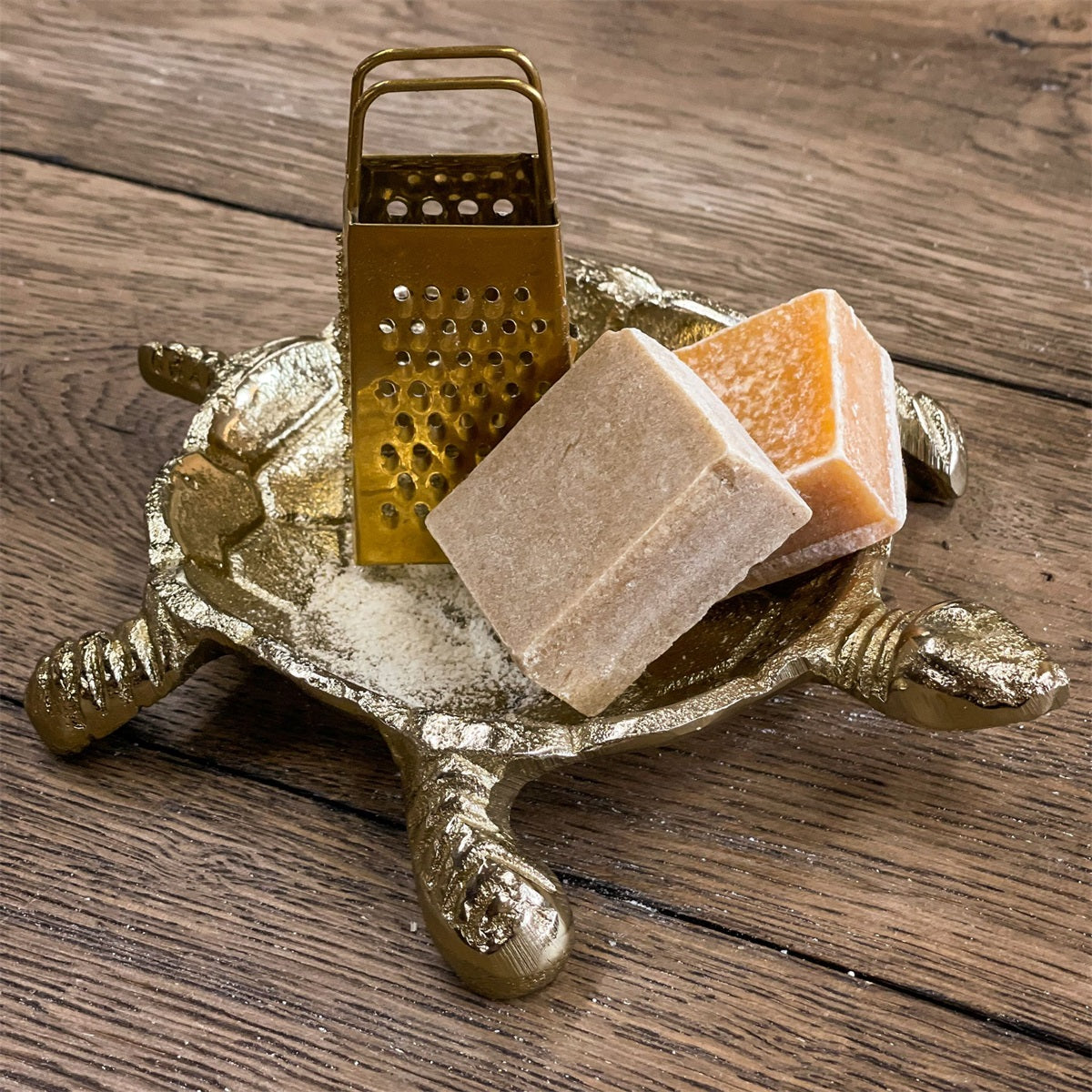 Goldene Schildkrötenschale mit zwei Duftblöcken und einer Raspel